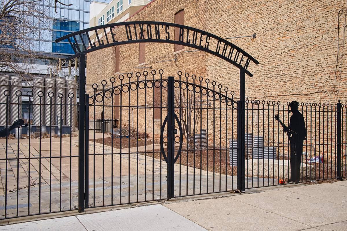 The iron gate of Willie Dixon’s Blues Garden beside a brick building