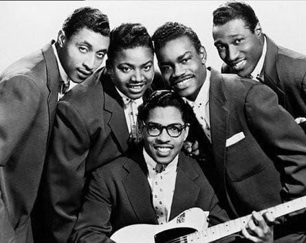 A vocal group of men in matching jackets posed together