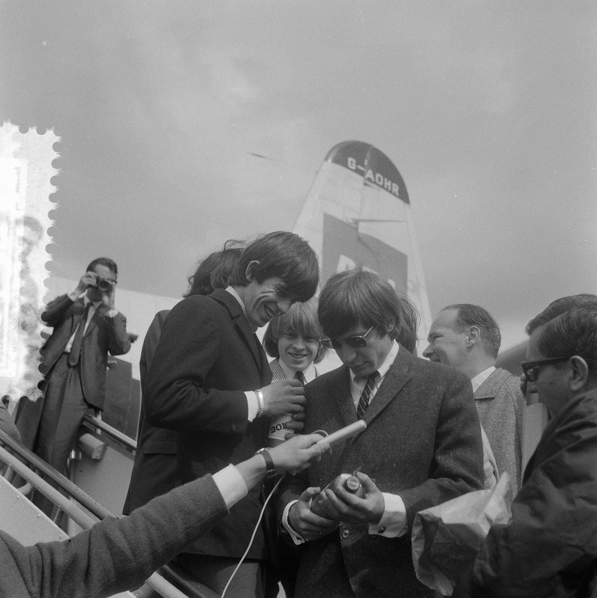 The five Rolling Stones in suits at an airport