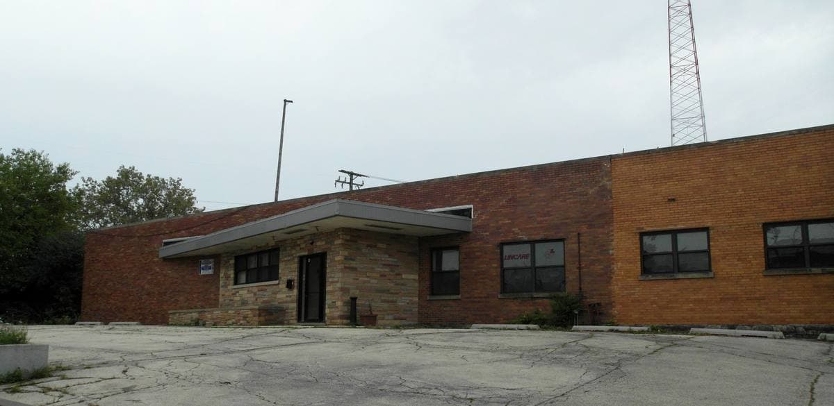A low brick broadcast building with a tall radio mast