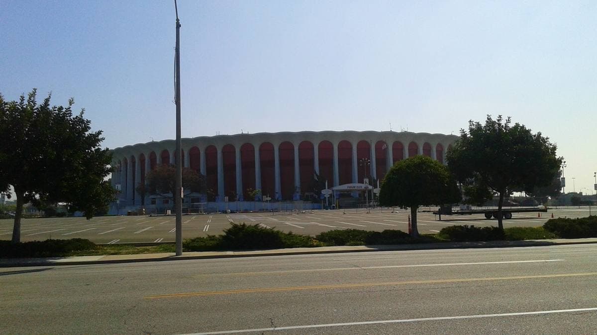 A round arena ringed with tall white columns under a blue sky
