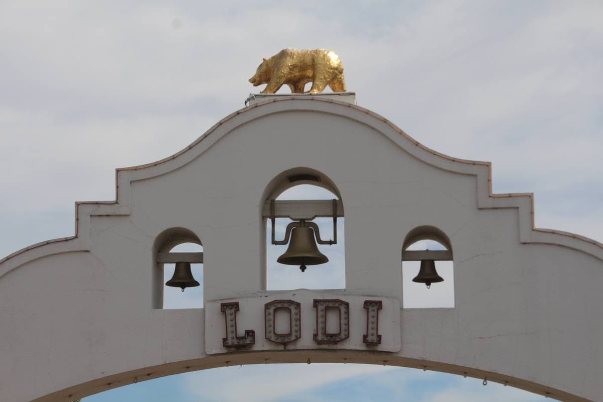 A white mission-style arch over a town street
