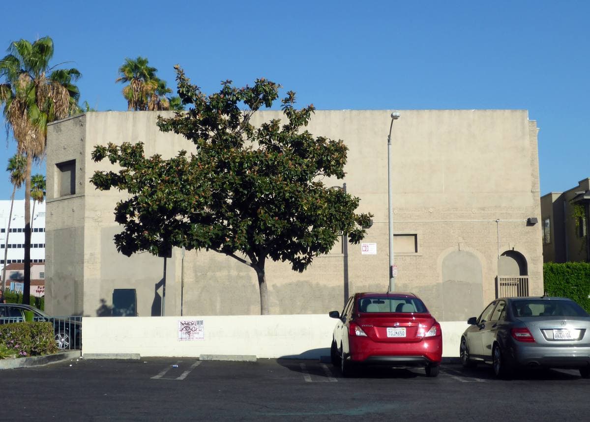 A low painted studio building on Sunset Boulevard with a striped awning