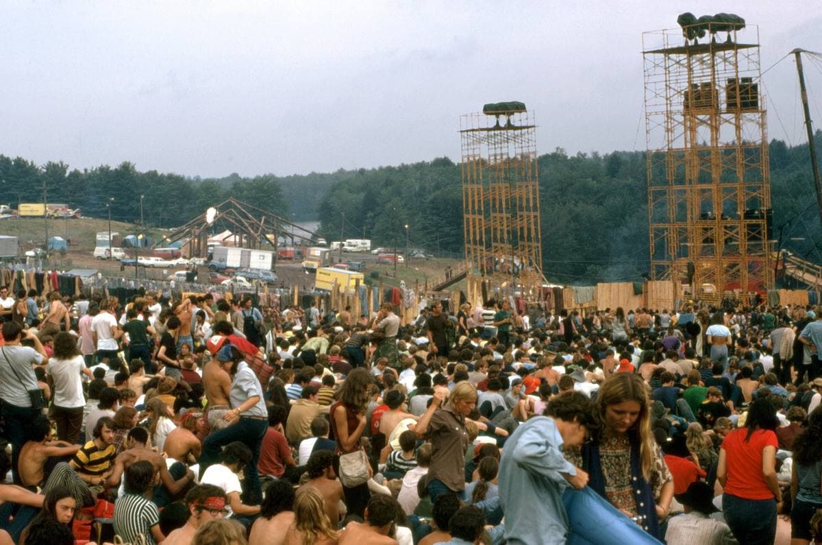 Scaffold towers rising over a hillside crowd under a grey sky