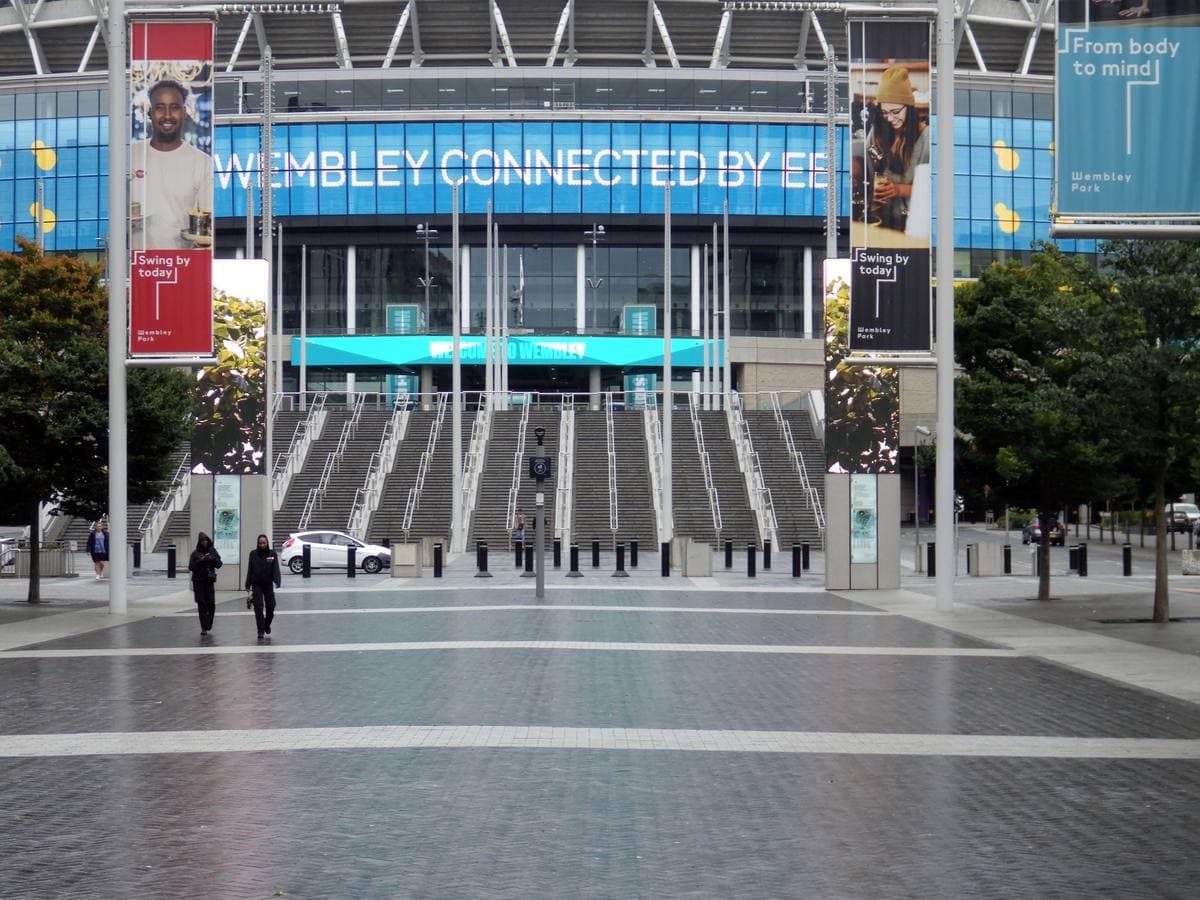 Wide stone steps leading up to the glass front of Wembley Stadium