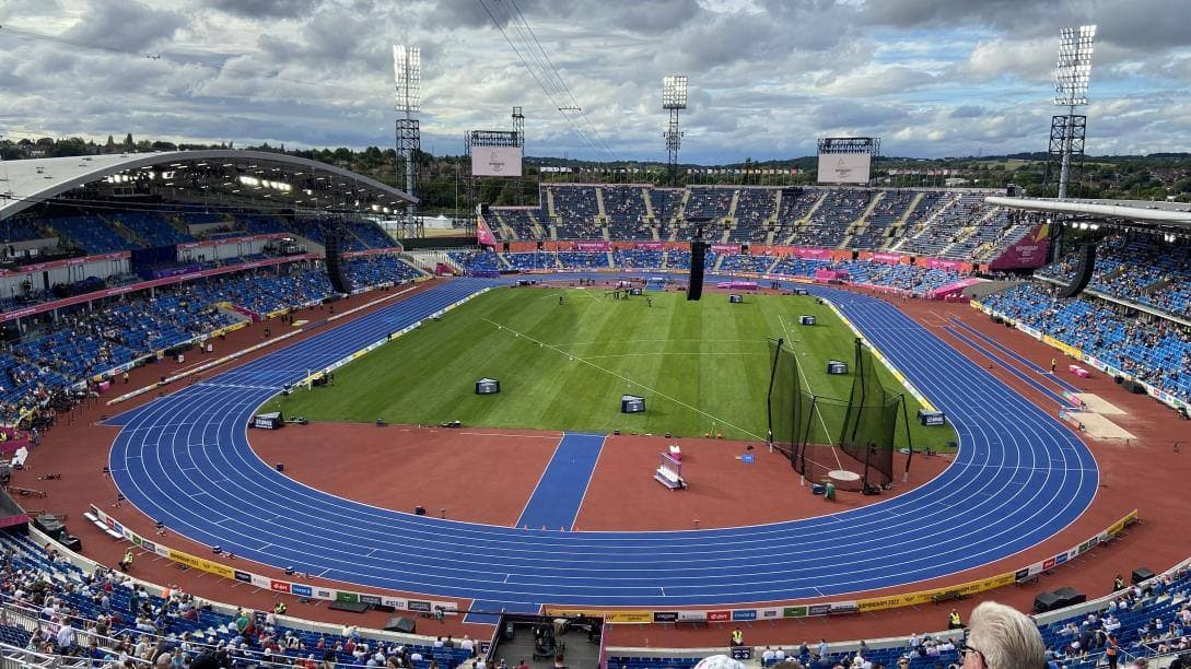 A full athletics stadium with a blue track, August 2022