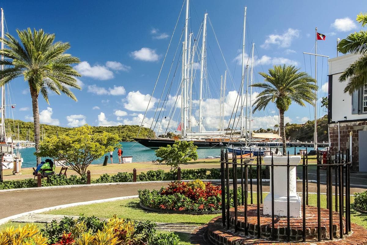 Old stone dockyard buildings beside a calm Caribbean harbour