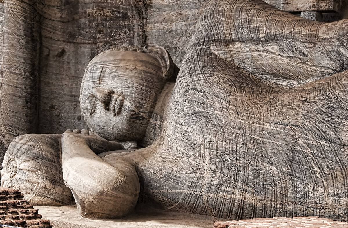Large standing and reclining Buddha figures carved into a granite rock face