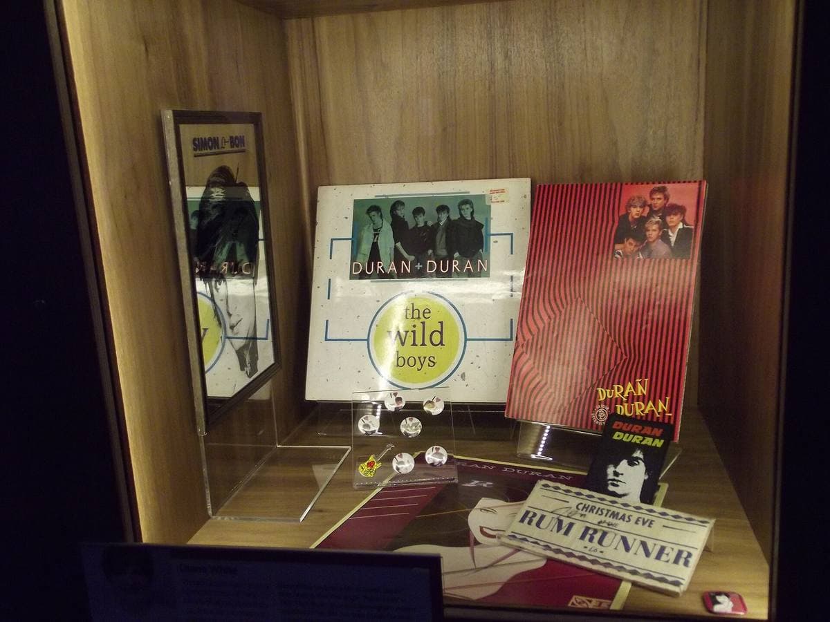 A museum display case about Duran Duran with photographs and records