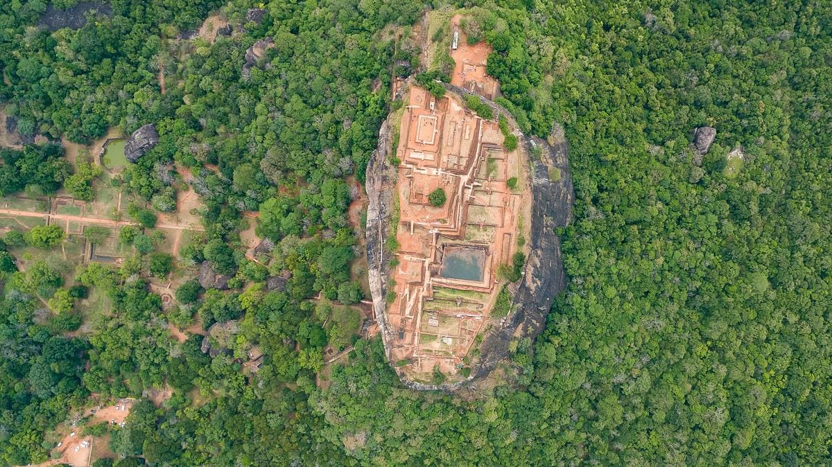 The flat-topped rock of Sigiriya rising out of green forest, seen from above