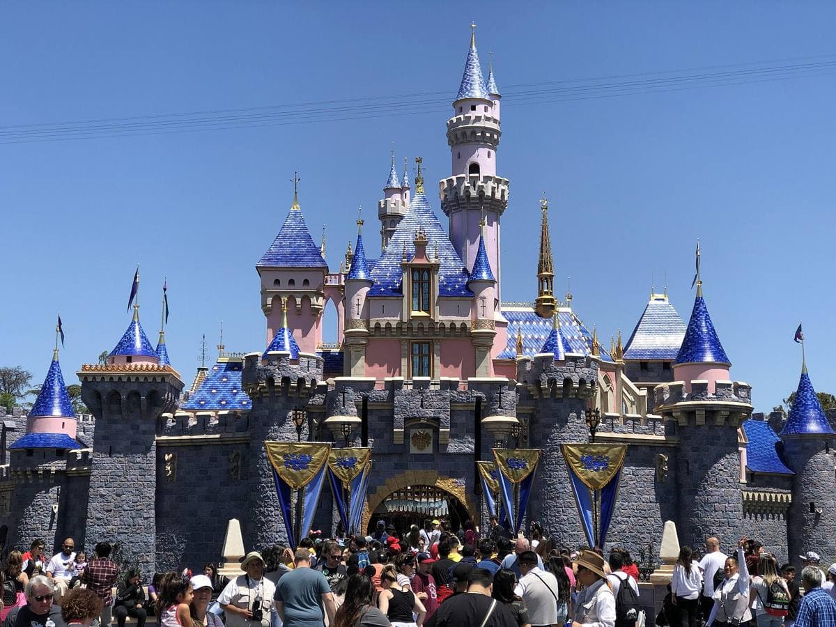 Sleeping Beauty Castle at Disneyland, pink and blue turrets against a clear sky