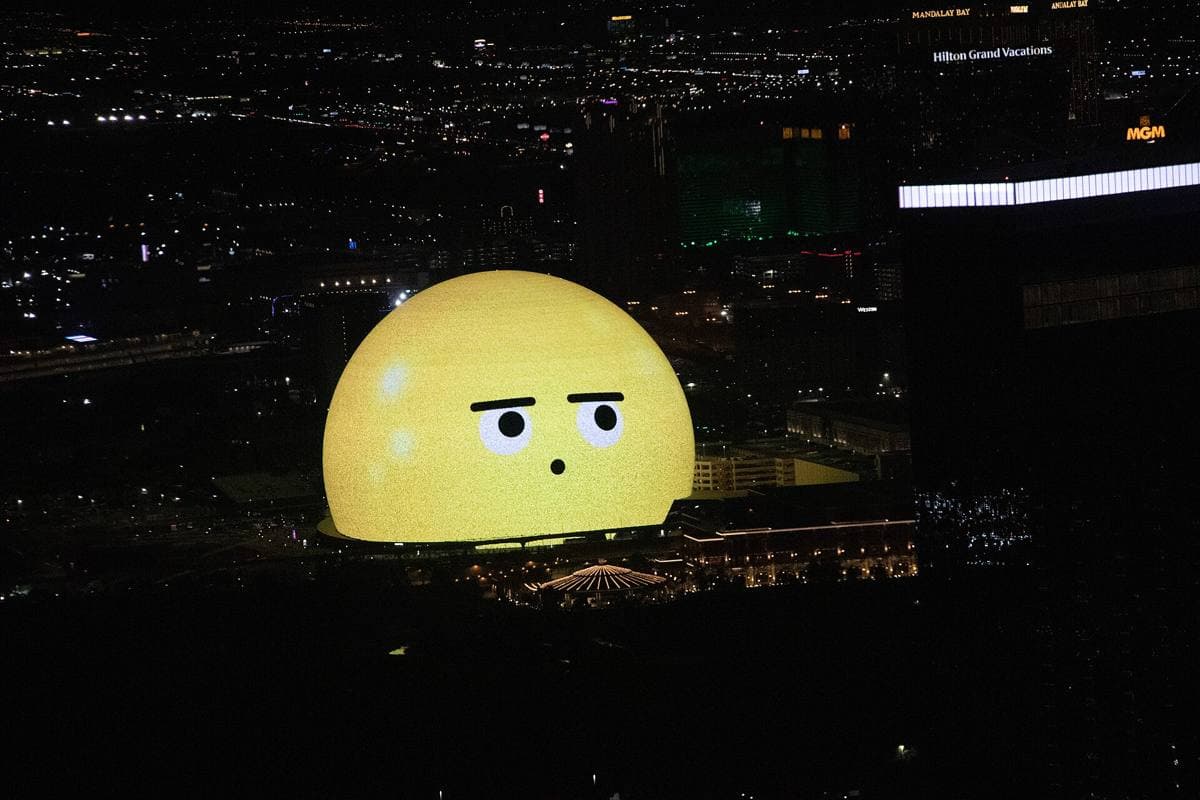 The giant lit globe of Sphere among Las Vegas hotels at dusk, seen from high above