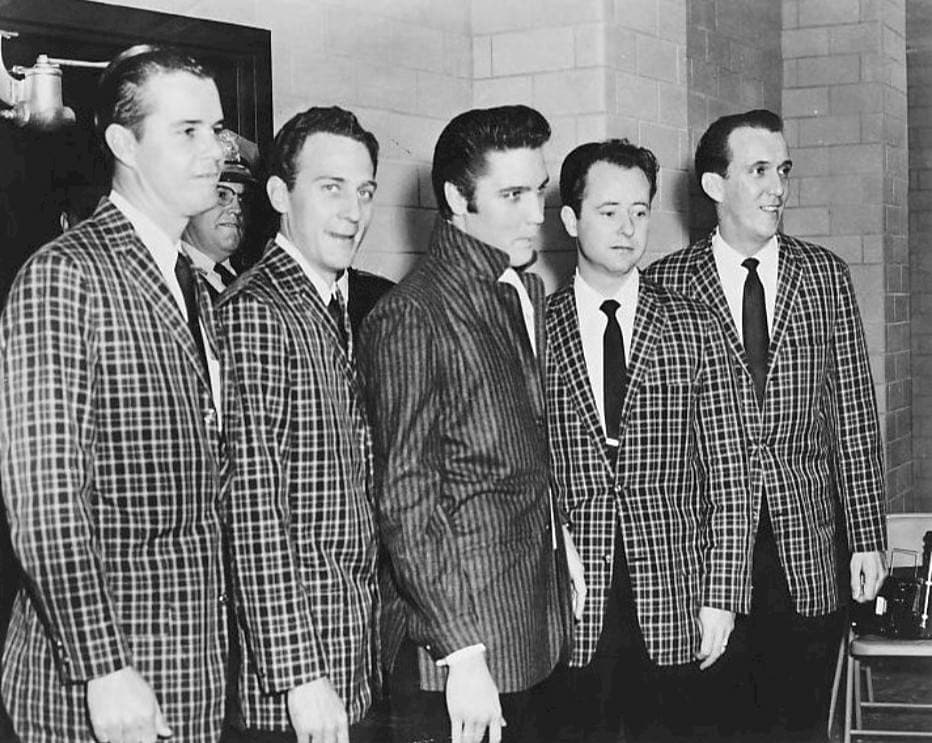 Elvis in a check jacket standing in a line with the four Jordanaires