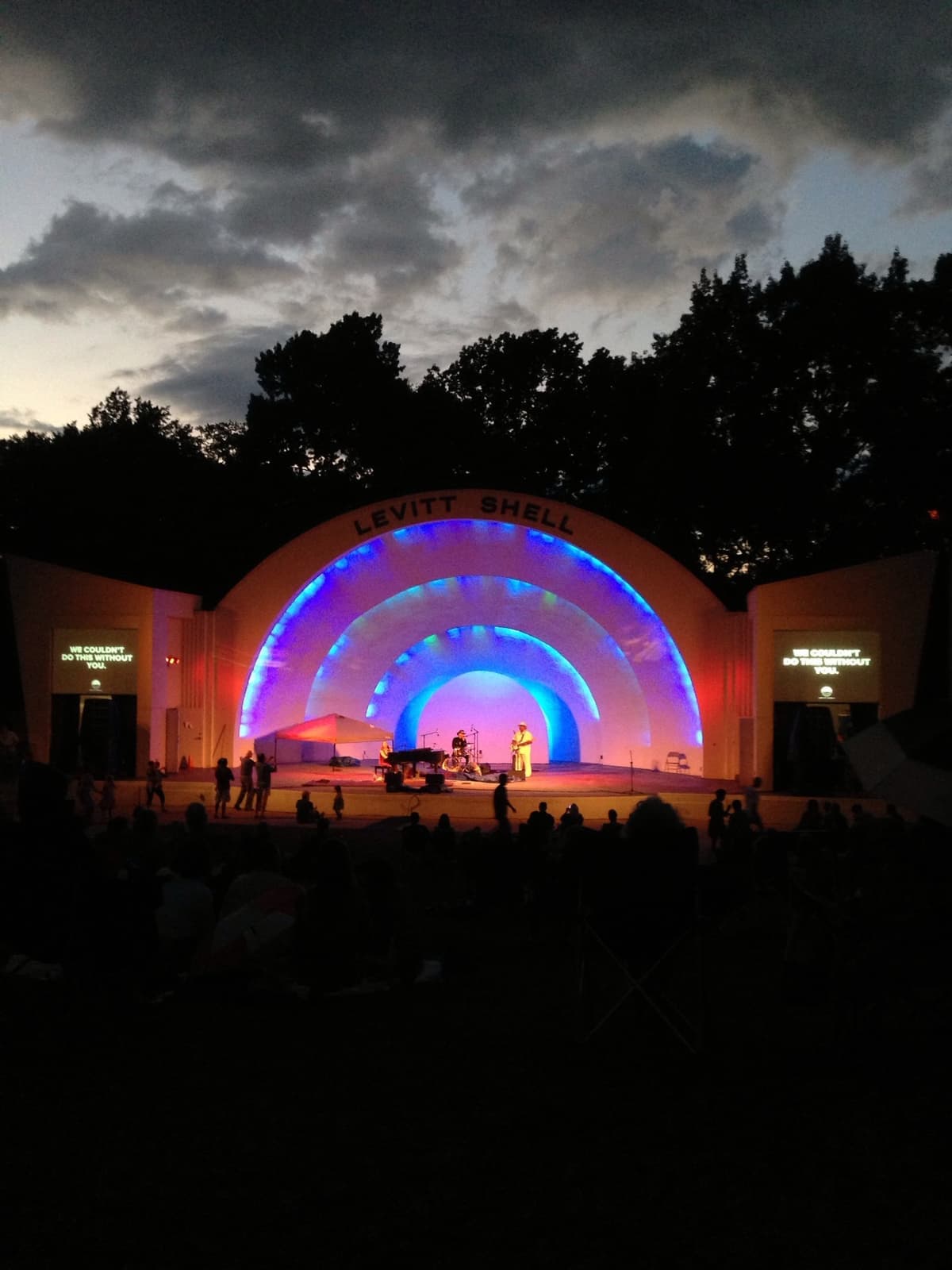 A white open-air bandshell at dusk