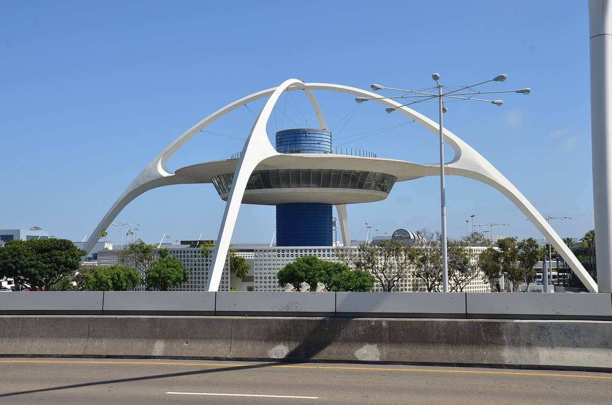 A white space-age building on curved arches lit at night