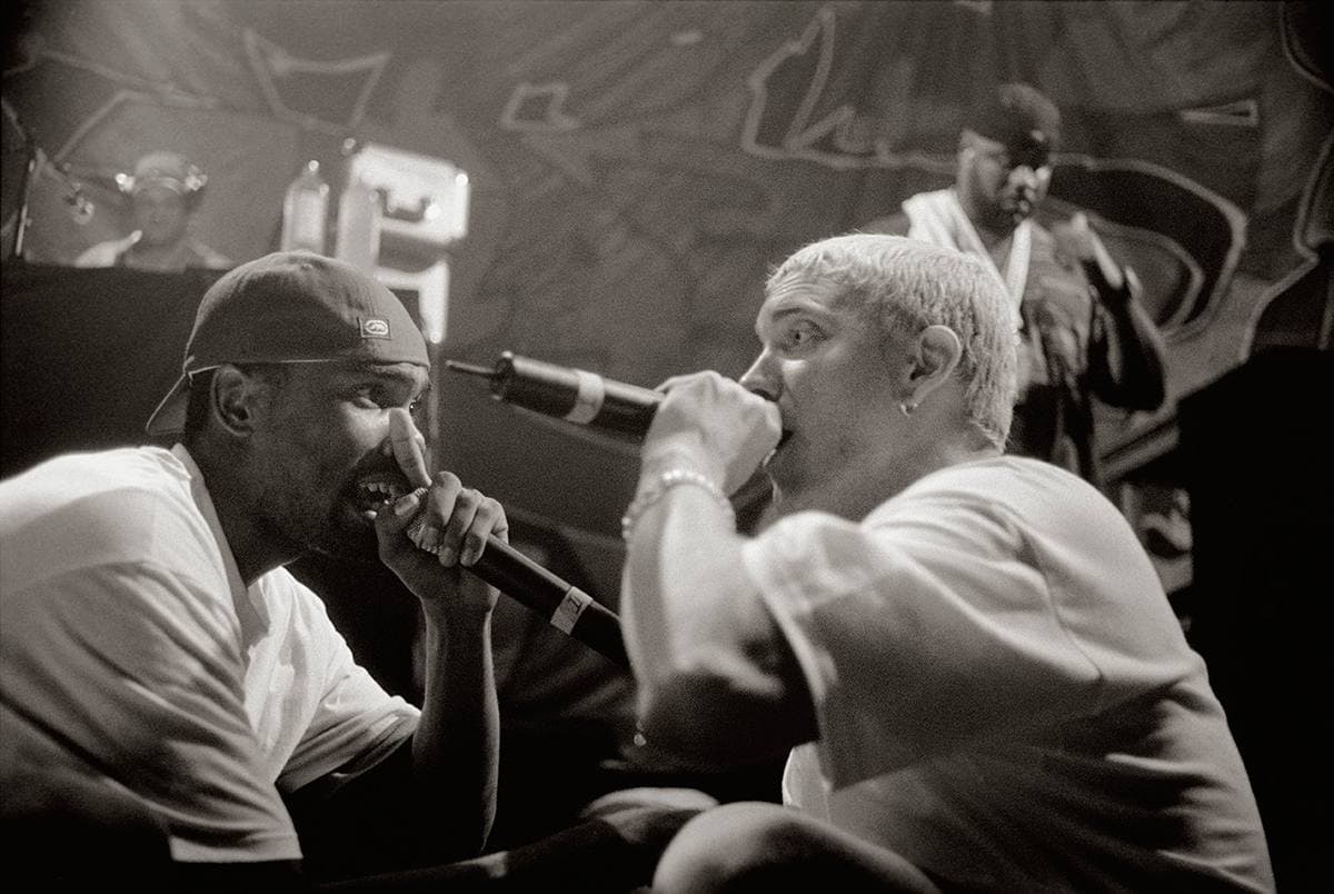 Proof in a backwards cap and Eminem with bleached hair rapping side by side into microphones