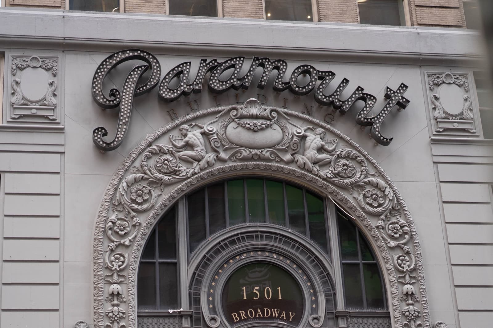 An ornate arch and a Paramount marquee on a Times Square building