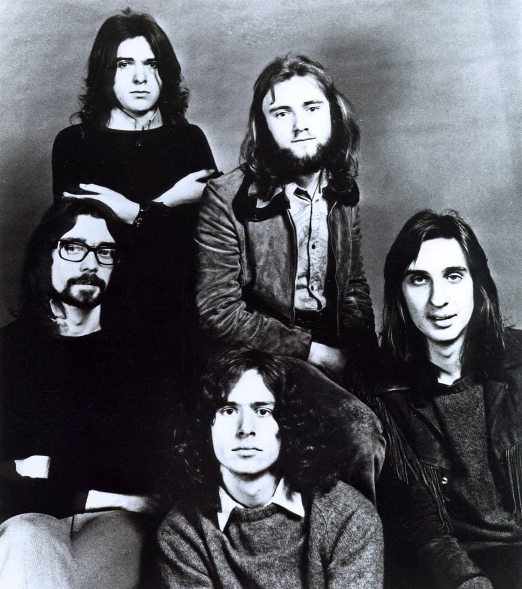 Five long-haired young men posed together in a black and white studio portrait