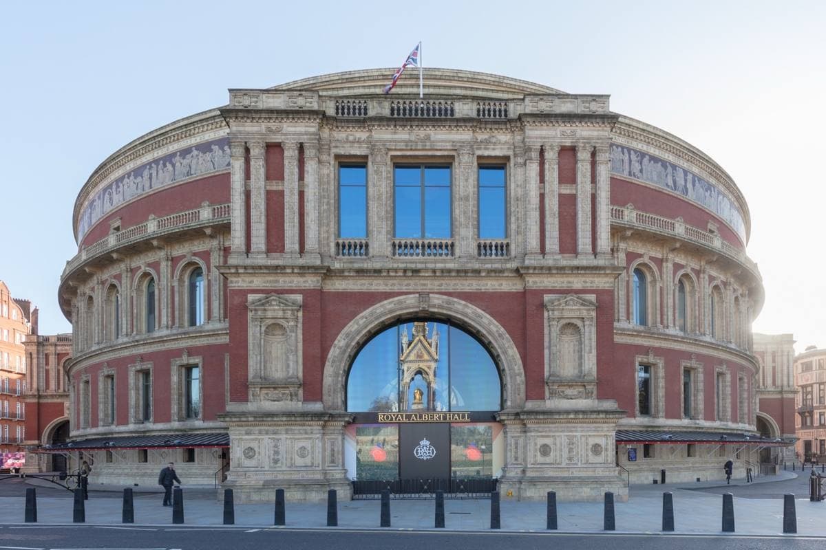 The round red-brick Royal Albert Hall with its arched glass porch, seen from the street