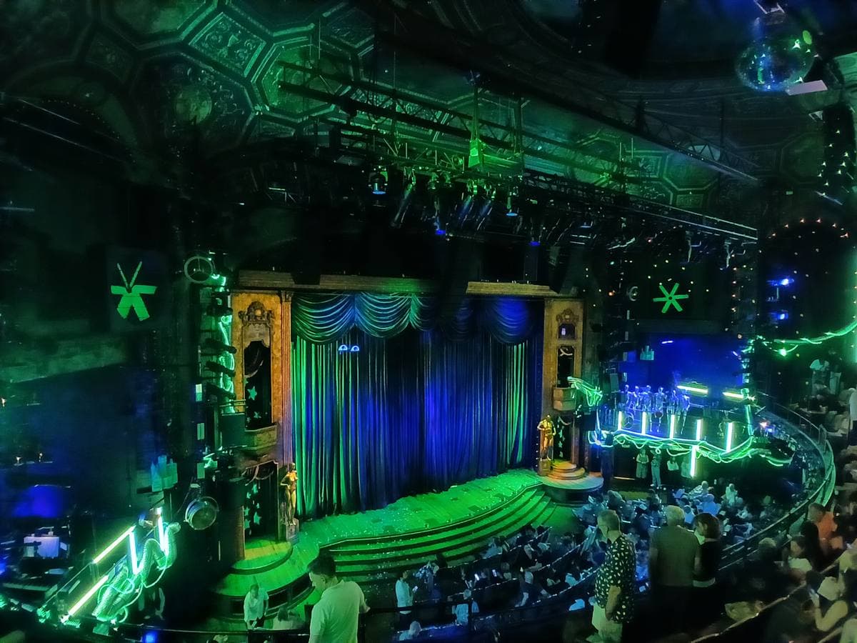 The auditorium of the Studio 54 theatre lit green and blue