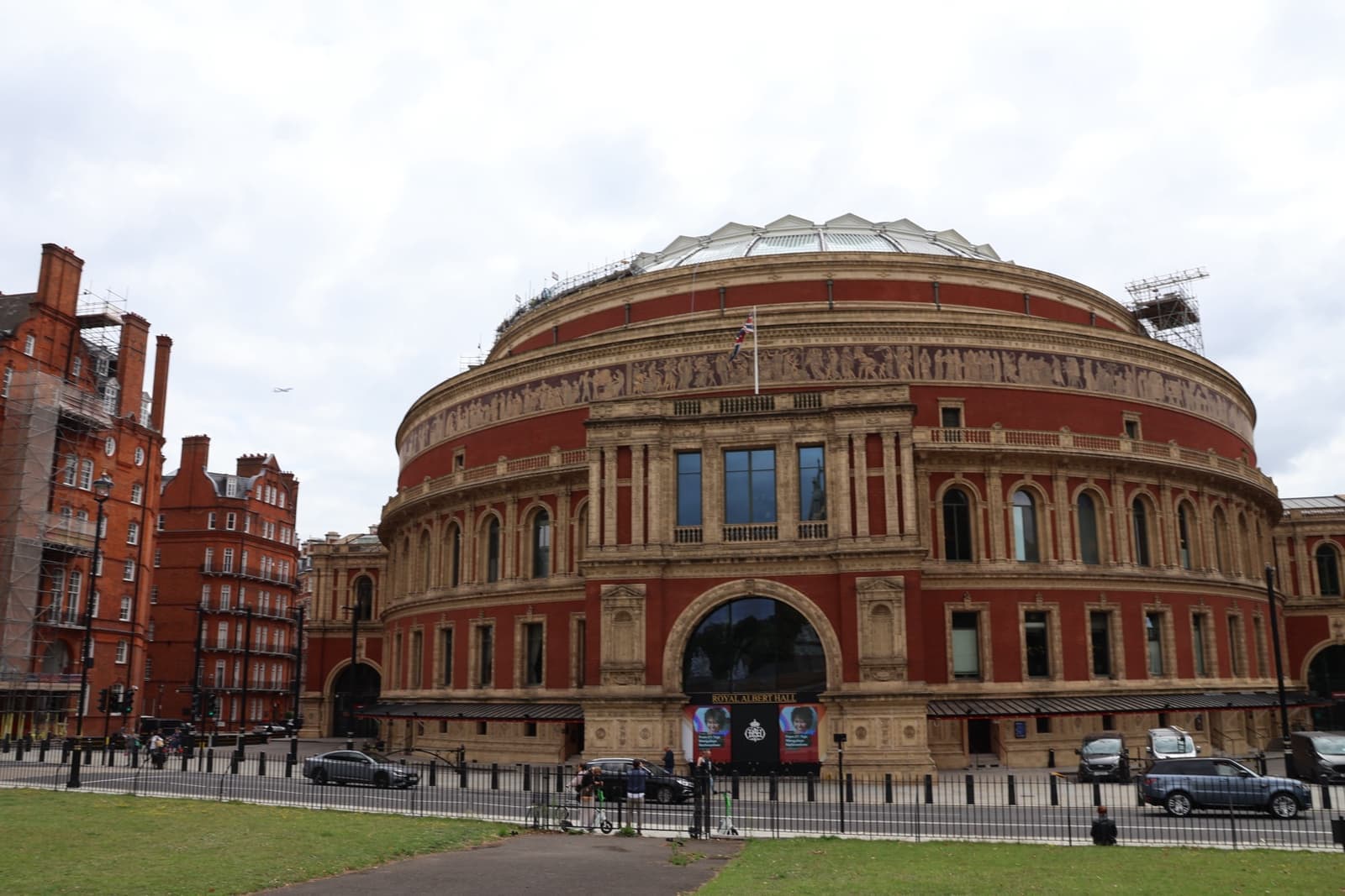 The round red-brick Royal Albert Hall with its glass dome, seen across the lawn