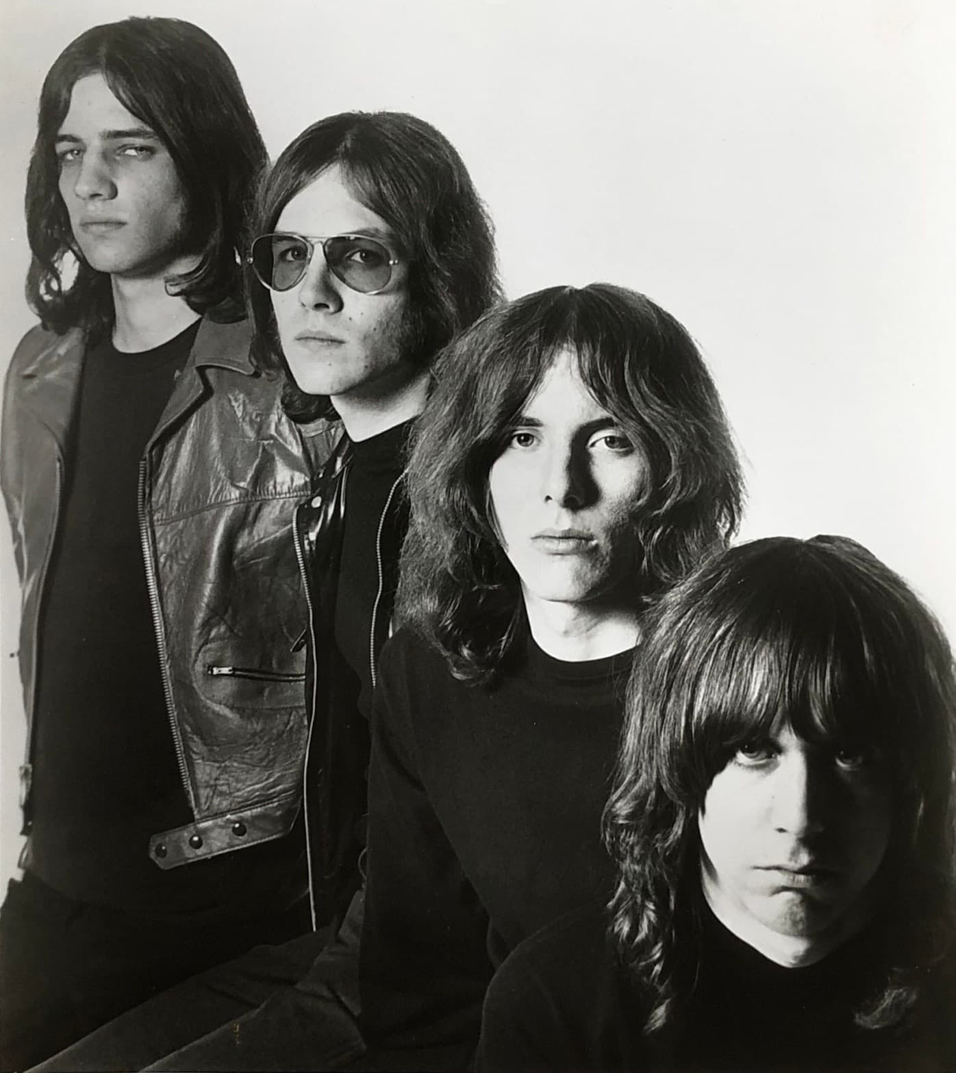 The four Stooges in black and white, long hair and leather, faces stacked close together