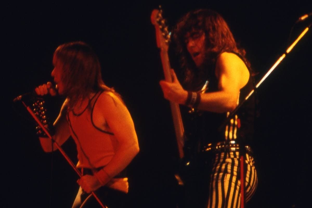 A singer and a bass player in red stage light