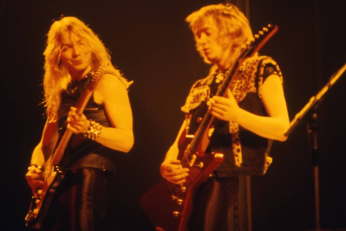 Two guitarists side by side in amber light
