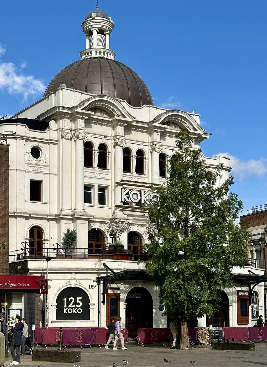 A domed white theatre front on a street corner
