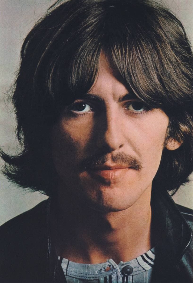 George Harrison with long hair and a moustache