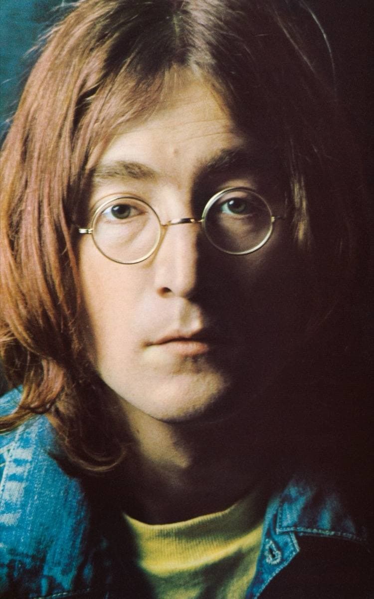John Lennon with long hair and round glasses