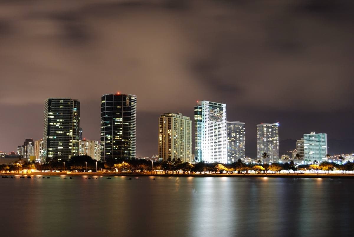 Lit towers along the Honolulu shore at night