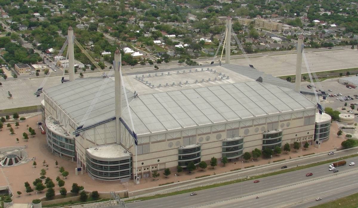 A white domed stadium with four tall yellow masts