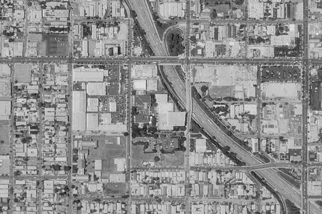 A black-and-white aerial view of a studio complex beside Sunset Boulevard