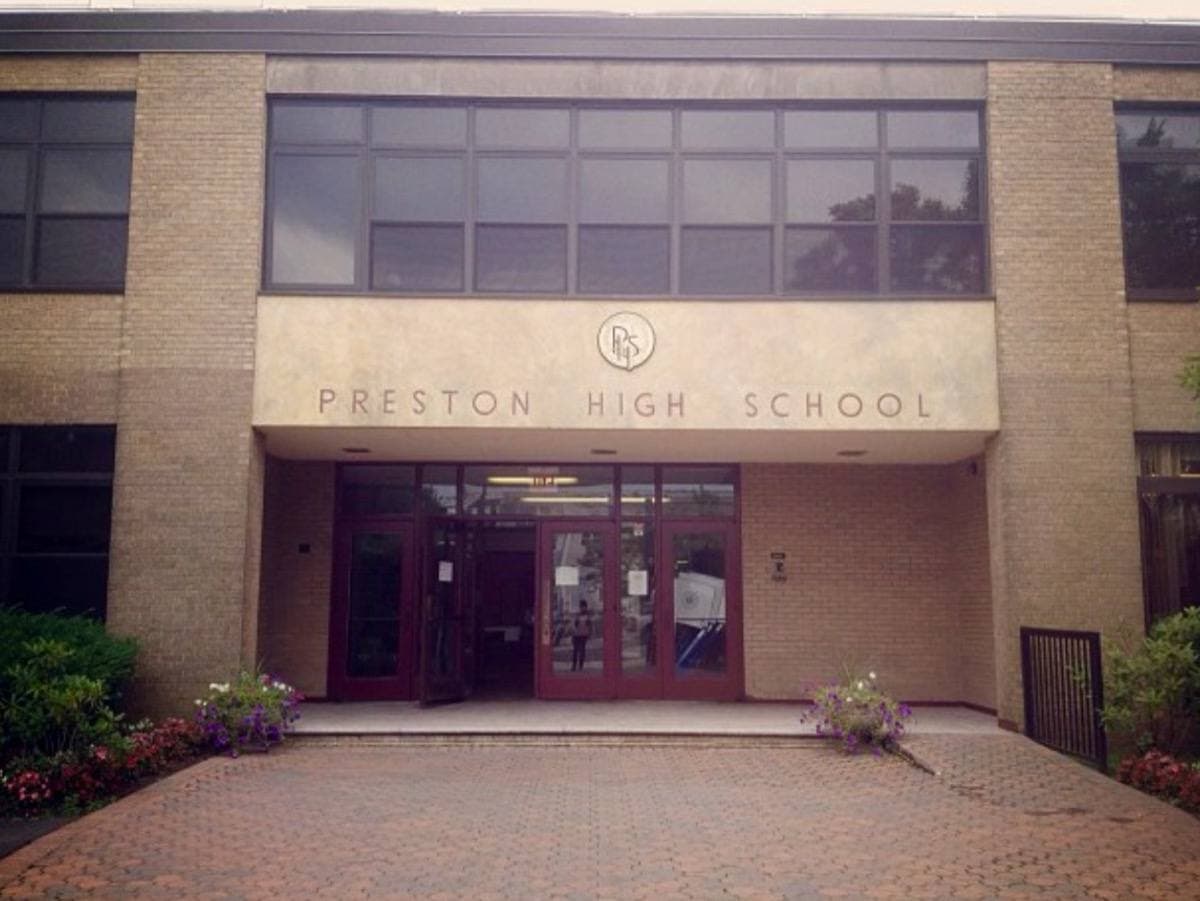 The entrance to a school campus behind a gate