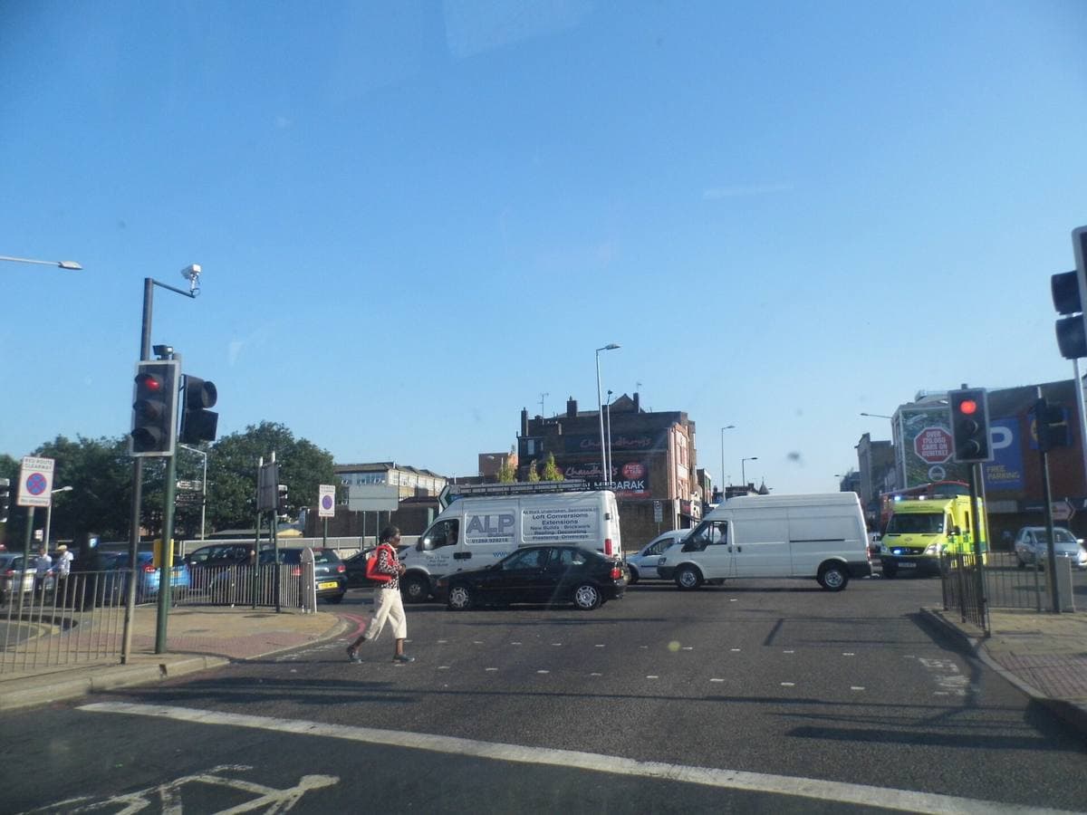 A busy road junction with traffic lights and vans