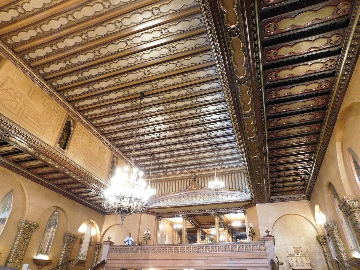 A gilded hall with chandeliers and Gothic arches