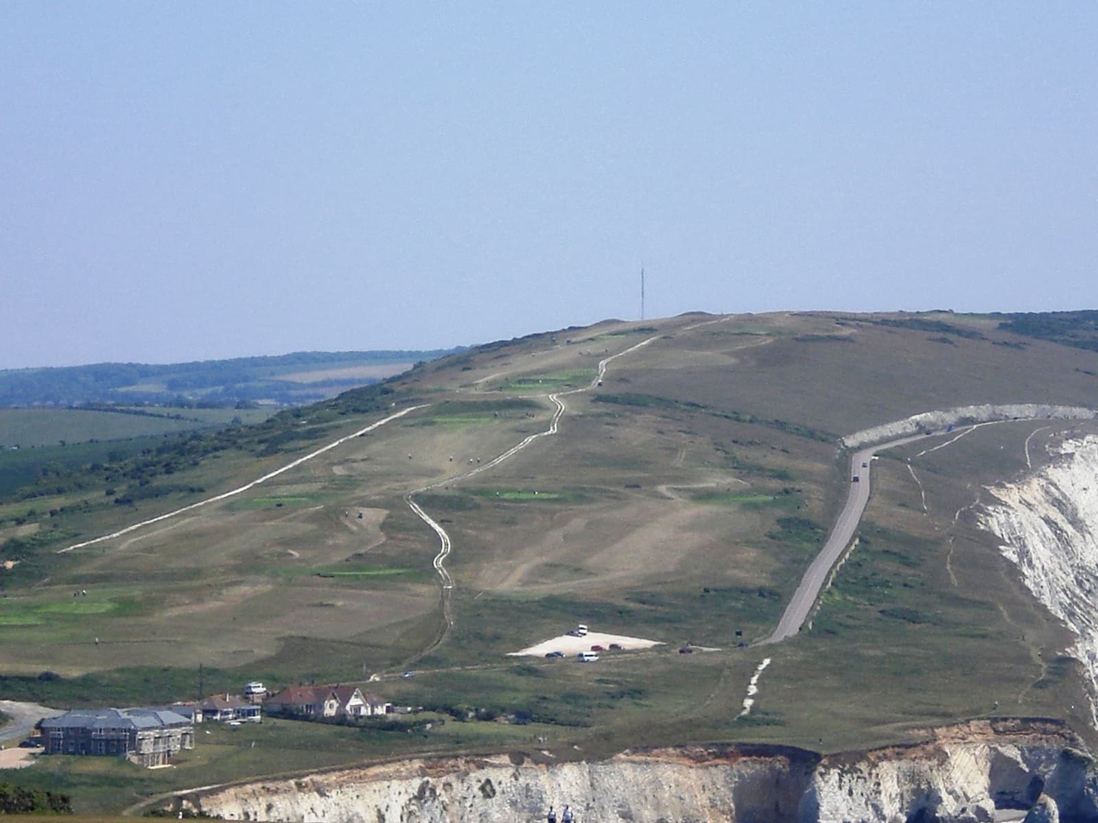 A long green chalk down rising above the sea cliffs