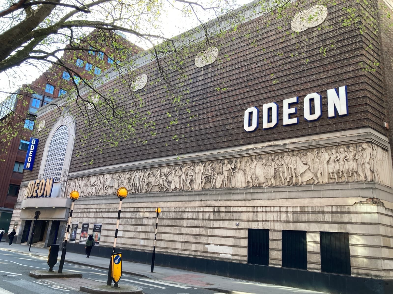 A long brick theatre front with a carved frieze and an Odeon sign