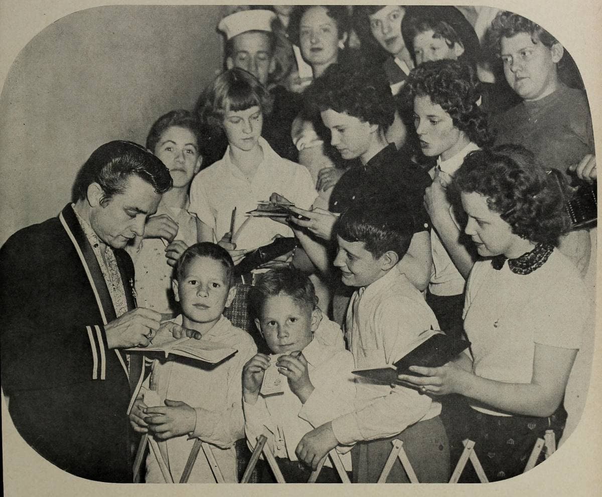 Johnny Cash signing autographs among a crowd of children