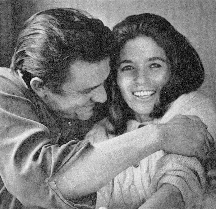 Johnny Cash hugging June Carter Cash, who is laughing