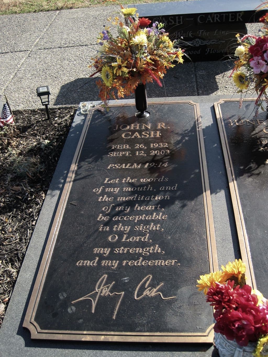 A flat granite grave marker with a signature
