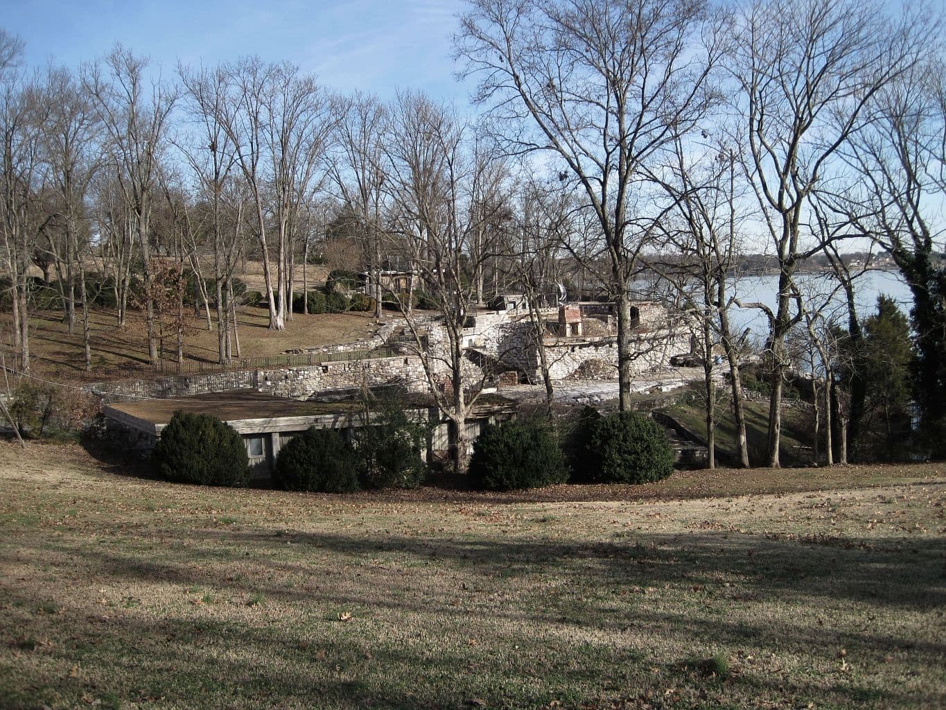Stone walls and a chimney among bare trees
