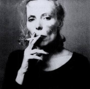 Black-and-white portrait of Joni Mitchell holding a cigarette to her lips
