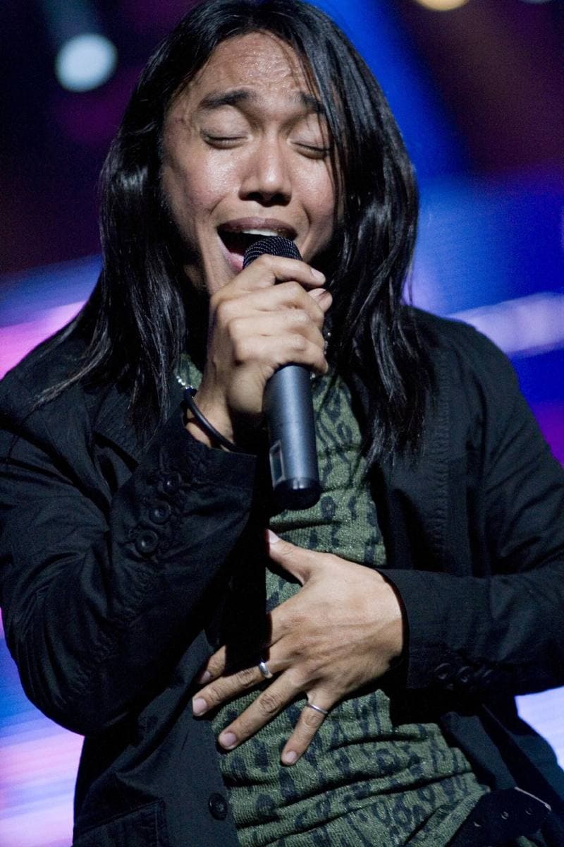 Arnel Pineda singing into a microphone on stage in 2008