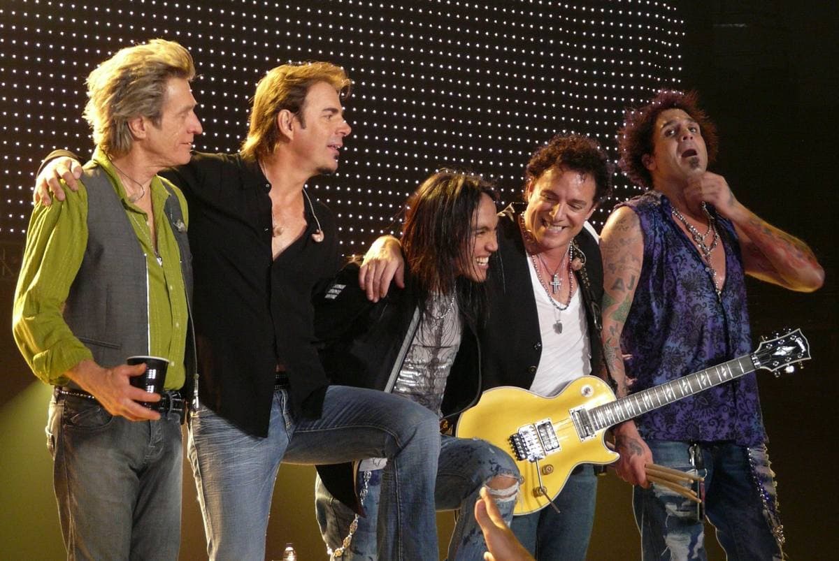 Journey on stage in 2008, Arnel Pineda singing at the centre with Neal Schon on guitar