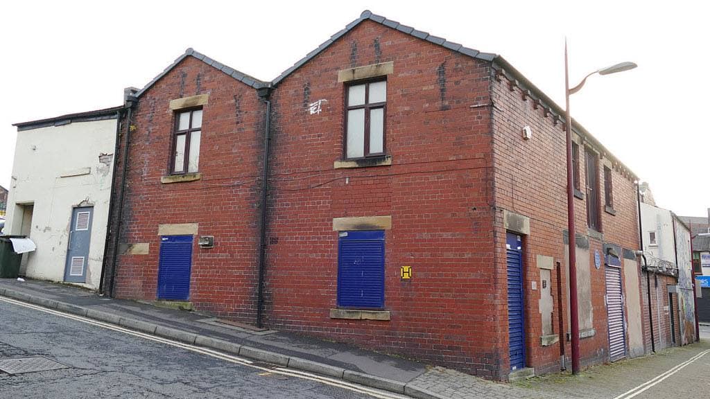A plain two-storey brick building on a corner of a quiet street