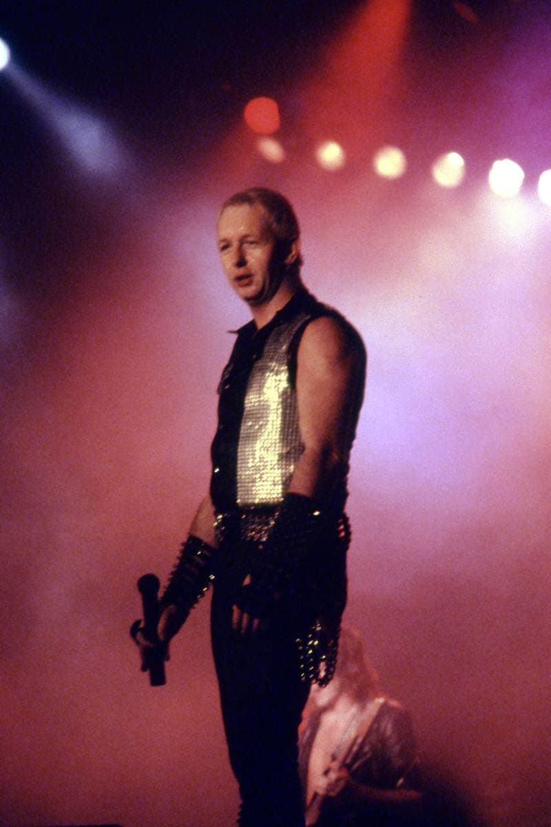 Rob Halford singing on stage in 1984 in black leather and studs