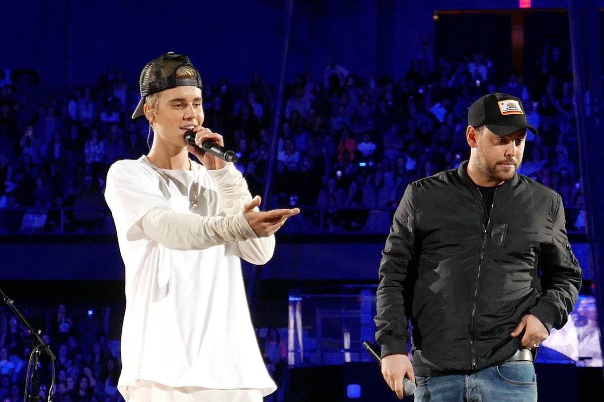 Justin Bieber and Scooter Braun side by side at an arena in 2015