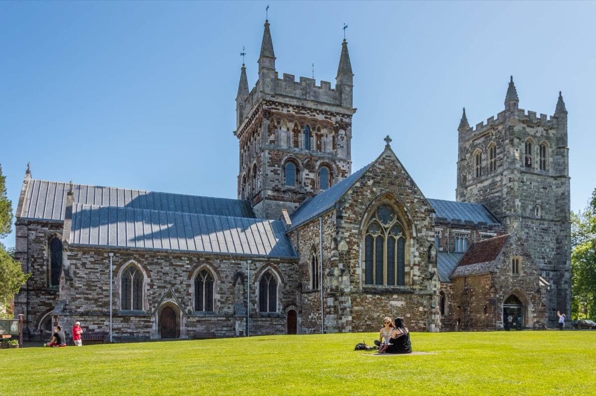 The towers of Wimborne Minster church under a blue sky